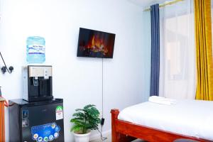 a room with a bed and a tv on the wall at Leisure BnB in Kiambu