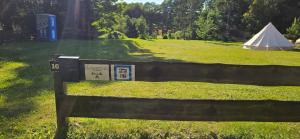 a sign on a fence in a field with a tent at Camping - Wohnmobilstellplatz in der Seenplatte in Carpin