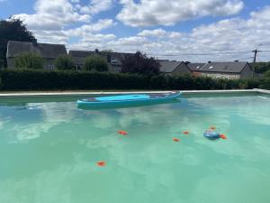 a pool of blue water with two boats in it at Ferme de Filot 3 in Hamoir