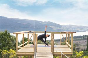 a man is doing yoga on a deck at Neusa Hills Eco Hotel Boutique in Tausa Viejo