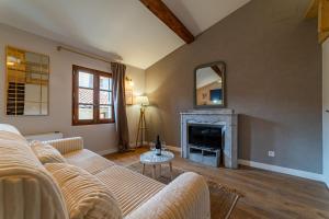 a living room with a couch and a fireplace at Duplex Caché Toits & Tradition in Sommières