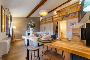 a kitchen with a wooden table with food on it at Duplex Caché Toits & Tradition in Sommières