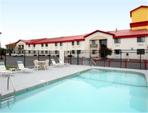 a large swimming pool with chairs and a building at Ramada by Wyndham Columbia in Columbia