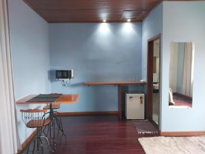a kitchen with a table and a counter in a room at Vila do Vento in Lavras Novas