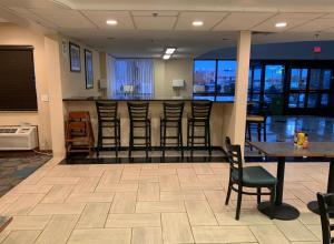 un bar avec des chaises et une table dans une pièce dans l'établissement Clarion Inn I-94 near Expo Center, à Kalamazoo