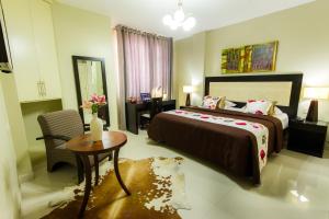 a bedroom with a large bed and a table and a chair at El Principe Hoteles in Piura