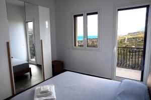 Habitación blanca con 1 cama y 2 ventanas en Trabia Casa Bianca B, en Mandra Capreria