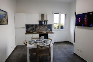 Una cocina con una mesa y sillas en una cocina. en Trabia Casa Bianca B, en Mandra Capreria