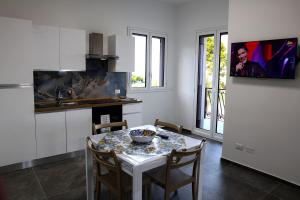 Una cocina con una mesa y sillas en una cocina. en Trabia Casa Bianca B, en Mandra Capreria