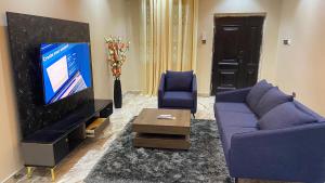 a living room with a purple couch and a tv at Norichyank Apartments in Amasaman