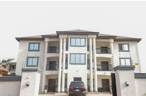 a car parked in front of a large building at Luxecom Apartments in Ashalebotwe