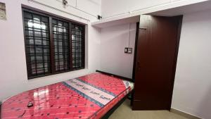 a small bed in a room with a window at Rock Hill - Pachakkad Home Stay in Athirappally