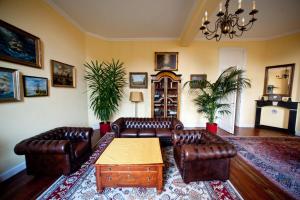 sala de estar con muebles de cuero y mesa en Chateau Neufays en Theux