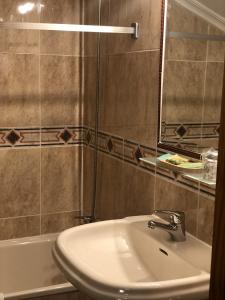 a bathroom with a sink and a mirror and a tub at Hotel Rural Villa Elena in Panes +22 photos