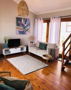 a living room with a couch and a tv at Cape Town cottage near colony of penguins in Simonʼs Town