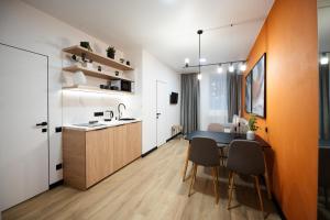 Una cocina y un comedor con mesa y sillas. en Апартаменти MYFREEDOM поруч Софіївська площа, Майдан Незалежності, en Kiev