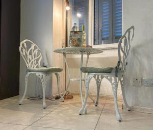 Traditional Maltese Townhouse في سليمة: كرسيين وطاولة مع طاولة وزجاجة