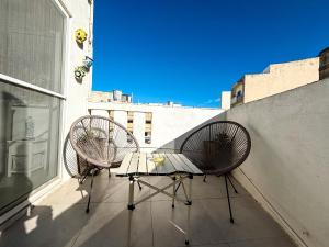 Traditional Maltese Townhouse في سليمة: كرسيين وطاولة على شرفة