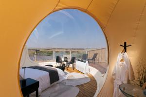 a bedroom in a tent with a large window at Vanara Eco Bubble - Experiência única na Natureza in Botucatu