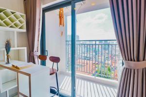 Habitación con escritorio y balcón con vistas. en Nice Condo - Soho Building, en Ho Chi Minh