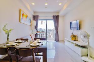 Una sala de estar con una mesa y un televisor. en Nice Condo - Soho Building, en Ho Chi Minh