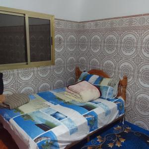Un dormitorio con una cama con una colcha encima en Auberge l'Etoile de ketama, en Tlata Ketama
