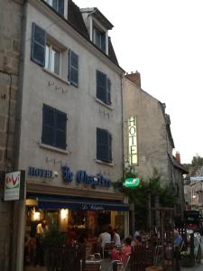 a building with people sitting outside of it at Hotel Le Chapitre in Aubusson