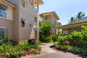 een loopbrug tussen twee gebouwen met bloeiende planten bij E34 Waikoloa Fairway Villas in Waikoloa