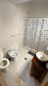 a bathroom with two toilets and a sink and a shower at San Remo Palace Hotel in Villa Gesell