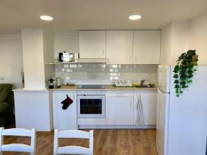 a kitchen with white cabinets and a refrigerator at Apartamento con vistas al río in Betanzos