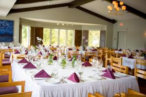 una grande sala da pranzo con tavoli bianchi e tovaglioli viola di Elmhirst's Resort a Keene