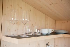 three wine glasses sitting on top of a shelf at Sleep Space 3 - Green Tiny Spot Friesland in Schortens