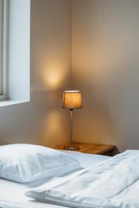 a lamp sitting on a table next to a bed at Solund Leileghetshotell in Hardbakke