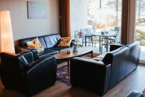 a living room with couches and a table and chairs at Solund Leileghetshotell in Hardbakke