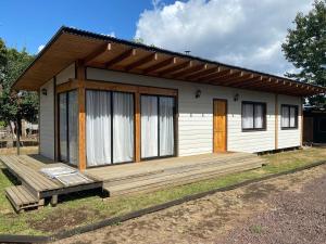 a small house with a large wooden deck at Cabaña M&R 2 in Lago Ranco
