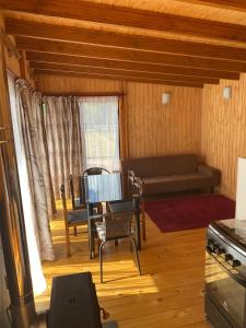 a living room with a couch and a table at Cabaña M&R 2 in Lago Ranco