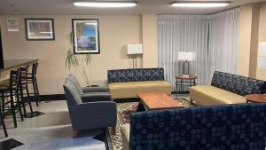 une salle d'attente avec des canapés, des chaises et une table dans l'établissement Clarion Inn I-94 near Expo Center, à Kalamazoo