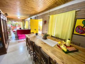 a dining room with a long wooden table and chairs at Pousada e Residencial Linda in Capão da Canoa