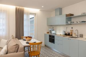 a kitchen and living room with a couch and a table at Carvoeiro Boutique Apartments in Amarante