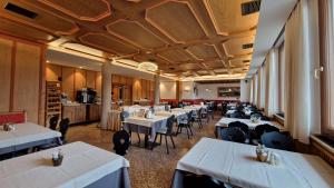 a dining room with white tables and chairs at Solaia Hotel & Guesthouse in Castelrotto