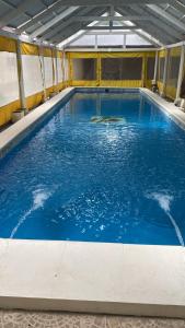 a large pool of blue water in a building at San Remo Palace Hotel in Villa Gesell