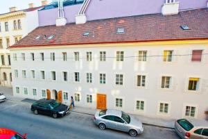 a large white building with cars parked in front of it at VOX Design Hotel in Vienna