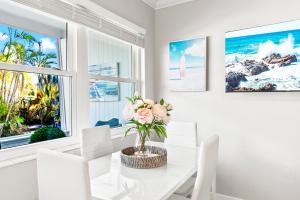 a dining room with a white table and chairs and a window at 100 Steps to beach access - 5 minute walk to the Village - Private Porch in Siesta Key