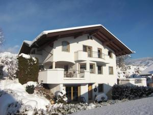 Una gran casa blanca con nieve en el suelo. en Astrid Schneeberger, en Fügen