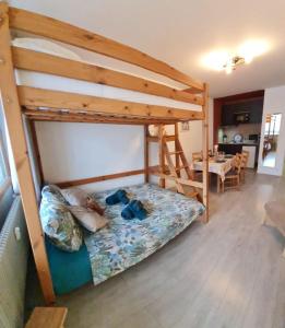a bedroom with a bunk bed and a table at La marmotte in La Bresse
