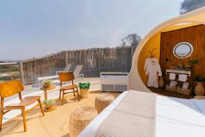 a room with a bed and chairs on a patio at Vanara Eco Bubble - Experiência única na Natureza in Botucatu +31 photos