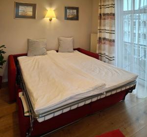a large bed in a room with a window at Wohnung 10 im Haus Hühnergott im Seepark in Ostseebad Sellin