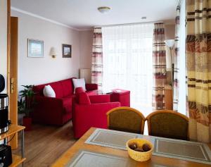 a living room with a red couch and a table at Wohnung 10 im Haus Hühnergott im Seepark in Ostseebad Sellin