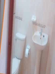 une salle de bains avec toilettes et lavabo dans l'établissement Rosa1, à Pucalá
