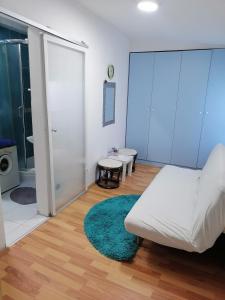 Habitación con cama blanca y alfombra verde. en Small low cost Dorcol, en Belgrado